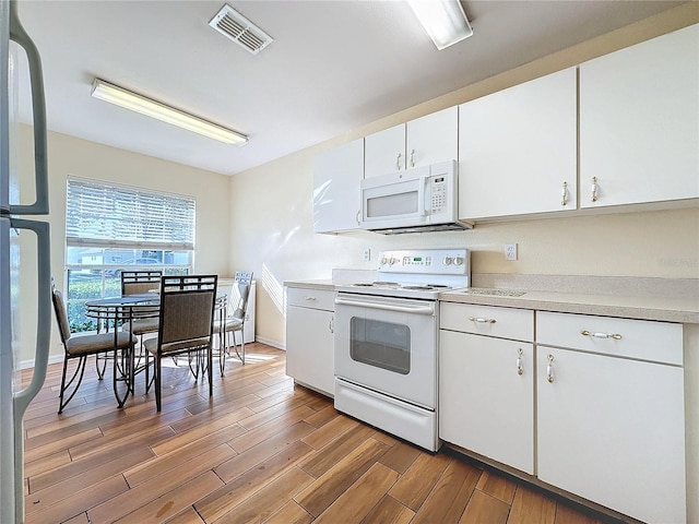 kitchen featuring white cabinetry and white appliances