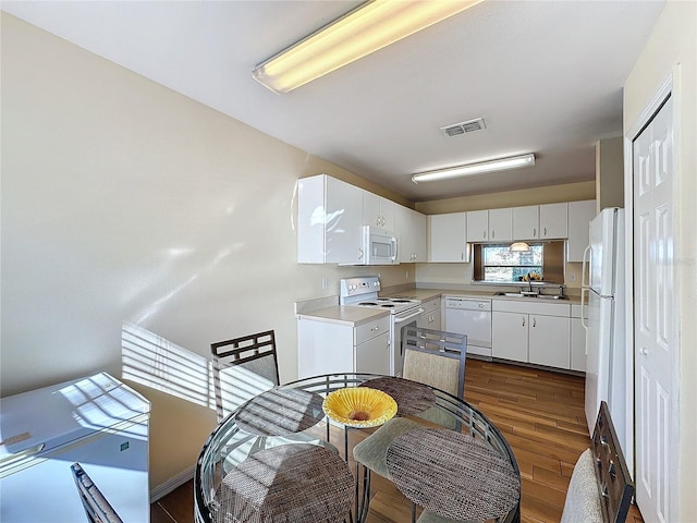 kitchen with white cabinets, white appliances, dark hardwood / wood-style floors, and sink