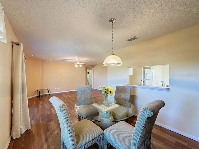 dining area with ceiling fan, wood-type flooring, and a textured ceiling