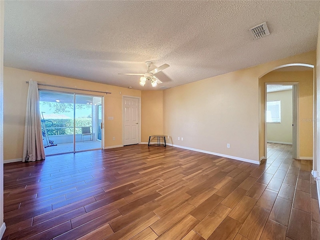 empty room featuring hardwood / wood-style floors, a textured ceiling, ceiling fan, and a healthy amount of sunlight