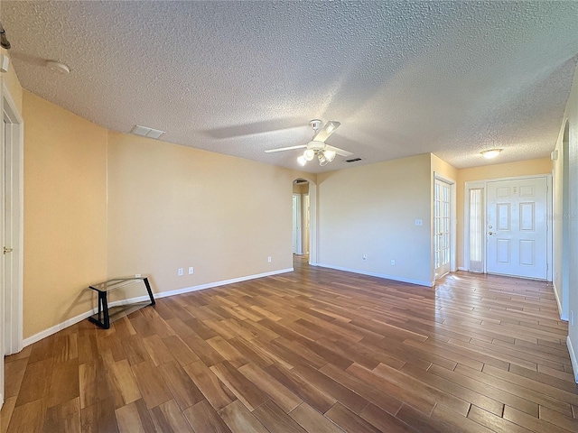 empty room featuring hardwood / wood-style floors, ceiling fan, and a textured ceiling