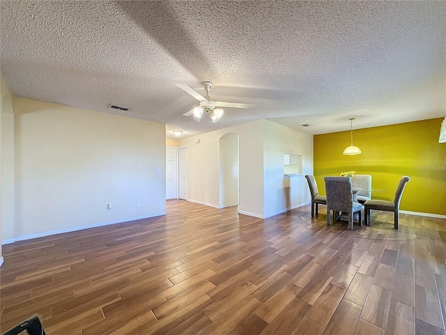 interior space with a textured ceiling, dark hardwood / wood-style flooring, and ceiling fan