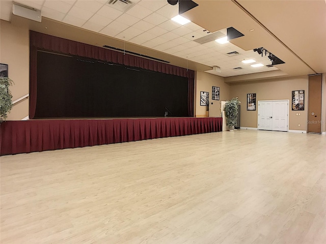 interior space with a drop ceiling and wood-type flooring