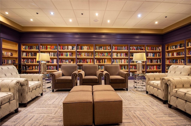 carpeted cinema room with a paneled ceiling