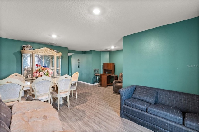 living room featuring a textured ceiling and light hardwood / wood-style flooring