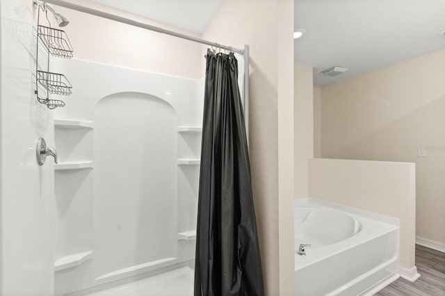 bathroom with hardwood / wood-style floors and independent shower and bath