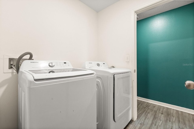 laundry area with light hardwood / wood-style floors and independent washer and dryer