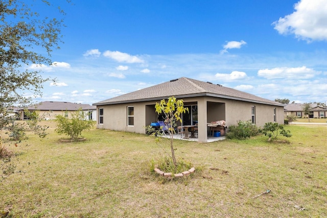 back of property with a yard and a patio