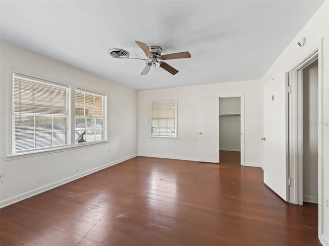 empty room with ceiling fan and dark wood-type flooring