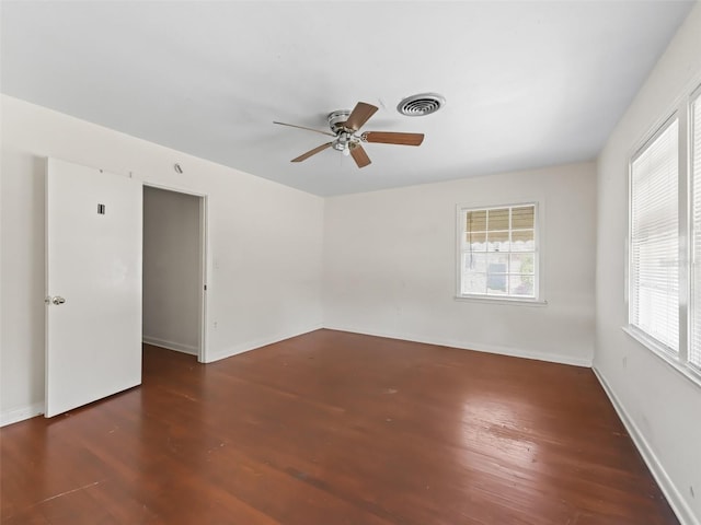 empty room with dark hardwood / wood-style floors and ceiling fan