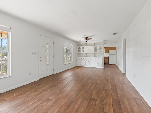 unfurnished living room featuring dark hardwood / wood-style floors and ceiling fan