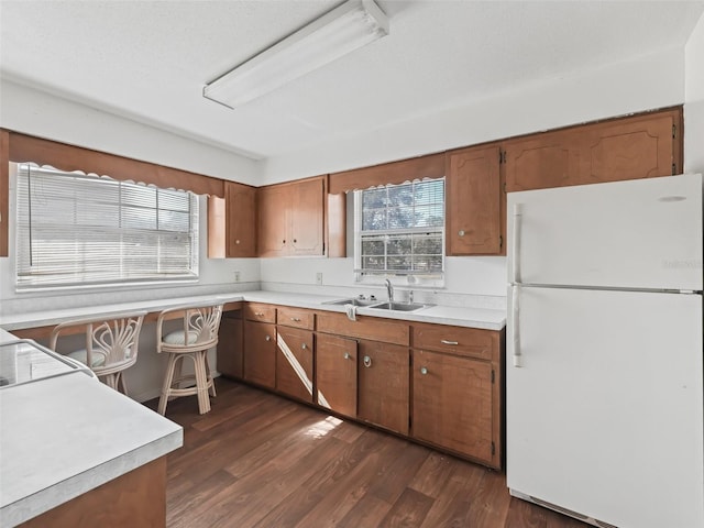 kitchen with sink, dark wood-type flooring, and white fridge