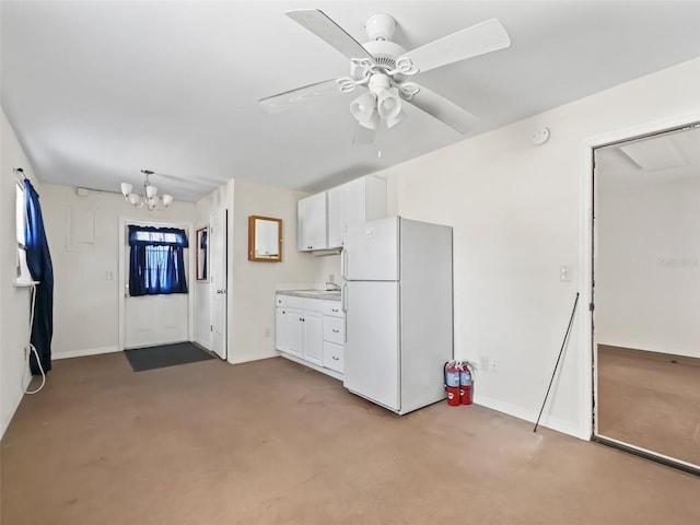 kitchen featuring sink, white cabinets, ceiling fan with notable chandelier, and white fridge