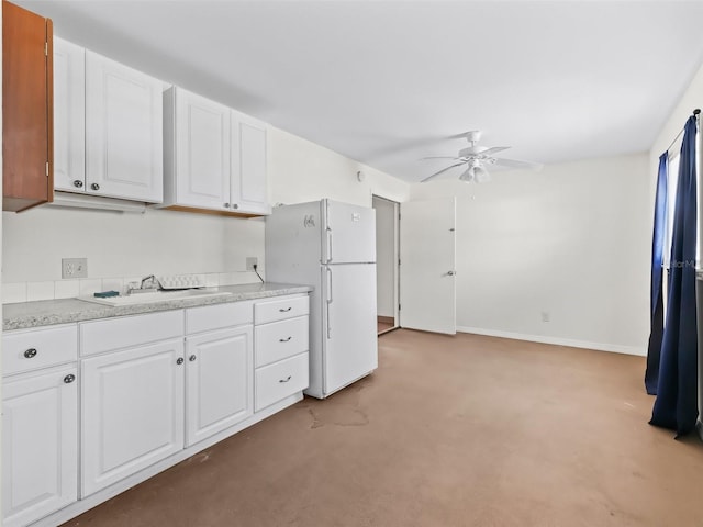 kitchen with white cabinets, ceiling fan, white refrigerator, and sink