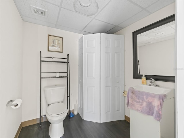 bathroom featuring sink, hardwood / wood-style floors, a paneled ceiling, and toilet