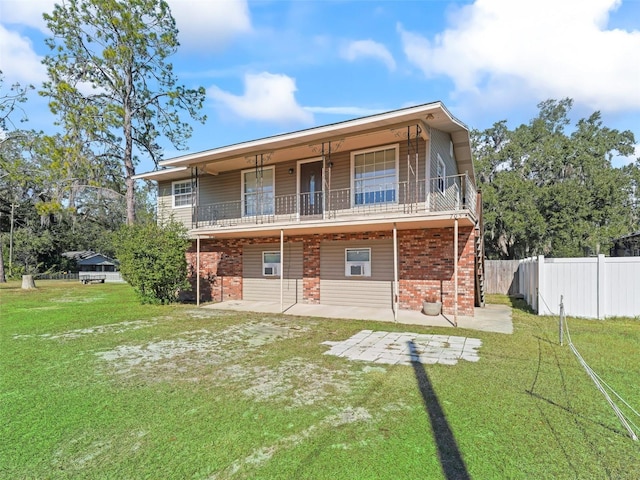 back of house featuring a lawn and a patio