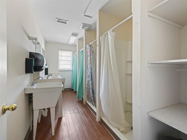 bathroom featuring hardwood / wood-style flooring and a shower with shower curtain