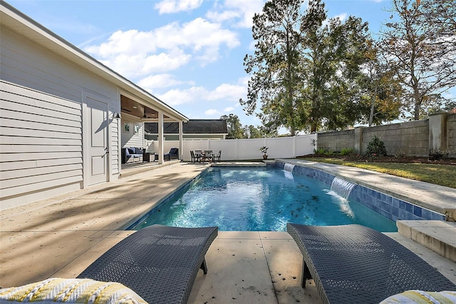 view of swimming pool with pool water feature, ceiling fan, and a patio