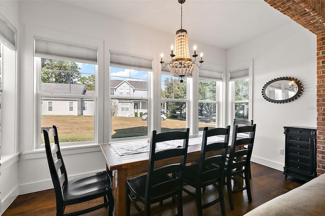 dining room with dark hardwood / wood-style floors and an inviting chandelier