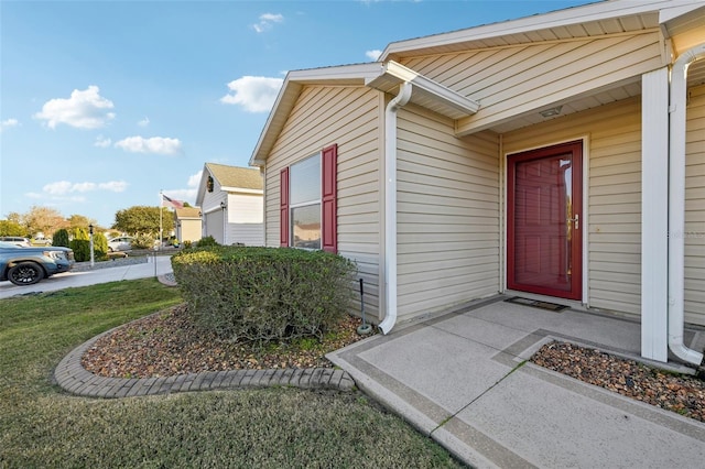 property entrance featuring a lawn