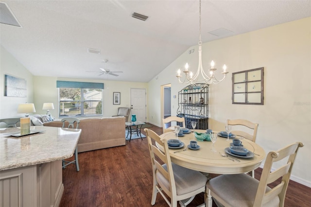 dining room with ceiling fan with notable chandelier, dark hardwood / wood-style floors, and vaulted ceiling