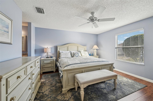 bedroom featuring a textured ceiling, ceiling fan, and dark wood-type flooring