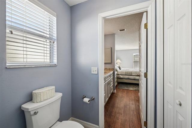 bathroom featuring hardwood / wood-style flooring, vanity, a textured ceiling, and toilet