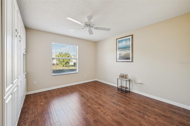 spare room with ceiling fan, dark hardwood / wood-style flooring, and a textured ceiling