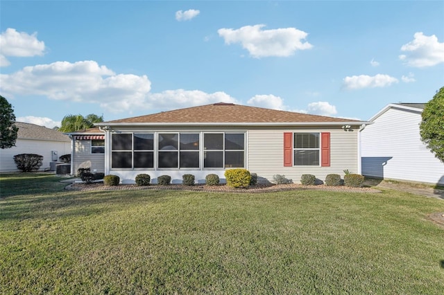 rear view of property featuring a sunroom and a yard