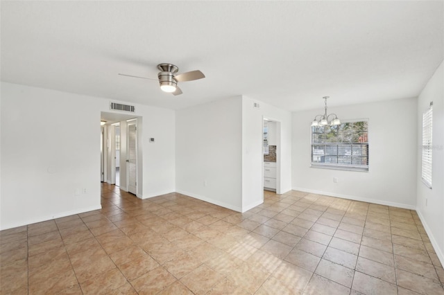 empty room featuring light tile patterned floors and ceiling fan with notable chandelier