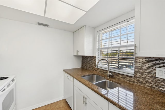 kitchen with sink, backsplash, dark stone countertops, white appliances, and white cabinets