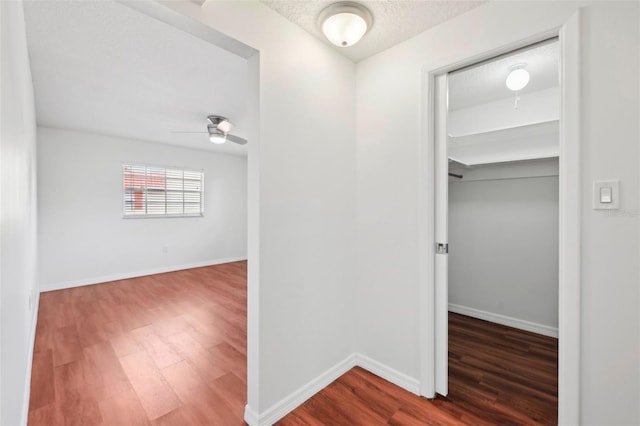 hallway with hardwood / wood-style floors and a textured ceiling