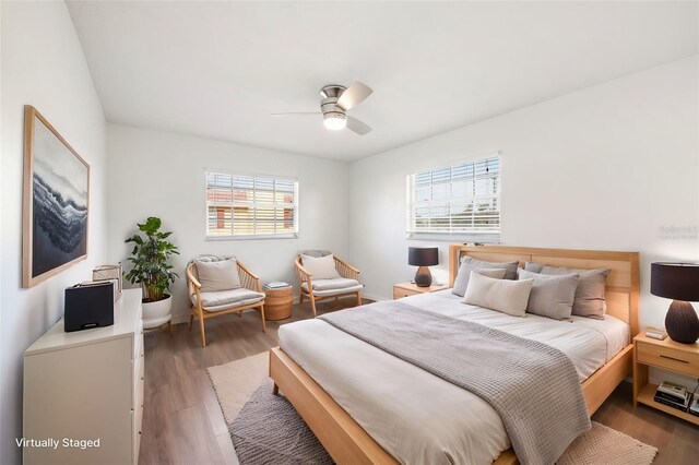 bedroom featuring multiple windows, ceiling fan, and dark wood-type flooring