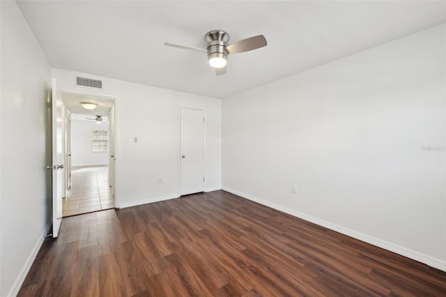 unfurnished bedroom featuring ceiling fan, dark wood-type flooring, and a closet