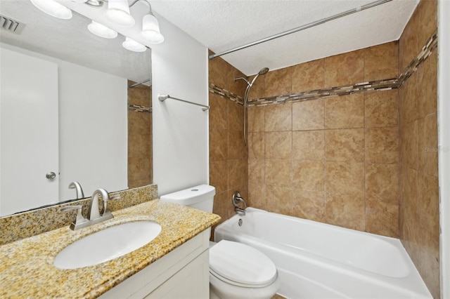 full bathroom featuring vanity, tiled shower / bath combo, a textured ceiling, and toilet