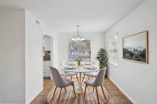 tiled dining area featuring an inviting chandelier