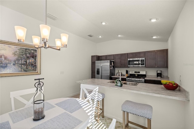 kitchen featuring stainless steel appliances, kitchen peninsula, decorative light fixtures, a kitchen bar, and dark brown cabinets