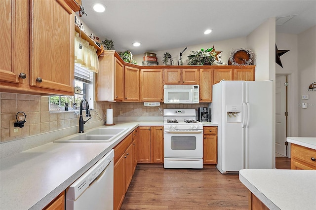 kitchen featuring hardwood / wood-style floors, white appliances, sink, vaulted ceiling, and decorative backsplash