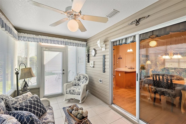 living area featuring a textured ceiling, ceiling fan, a healthy amount of sunlight, and light tile patterned flooring