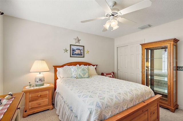 carpeted bedroom with ceiling fan and a closet