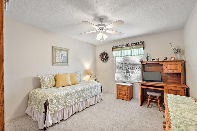 bedroom featuring light carpet, a textured ceiling, and ceiling fan