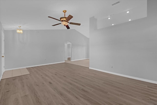 unfurnished living room with ceiling fan with notable chandelier and light wood-type flooring