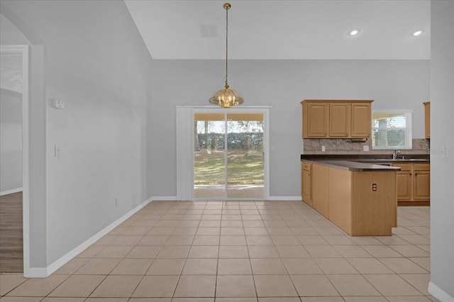 kitchen featuring backsplash, sink, light tile patterned floors, light brown cabinetry, and decorative light fixtures