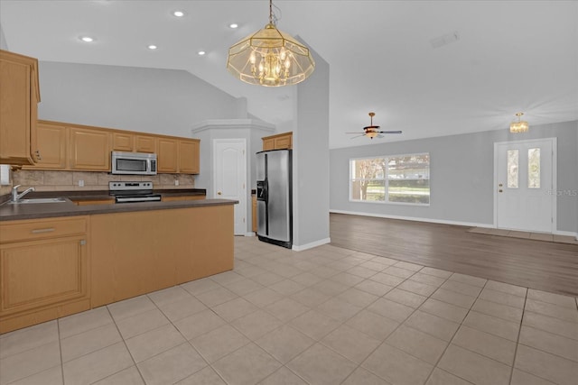 kitchen with ceiling fan with notable chandelier, stainless steel appliances, sink, light tile patterned floors, and hanging light fixtures