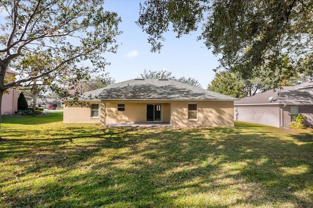 rear view of house with a yard and a patio area