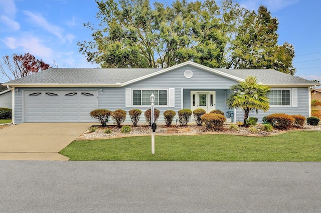 ranch-style home featuring a garage and a front lawn