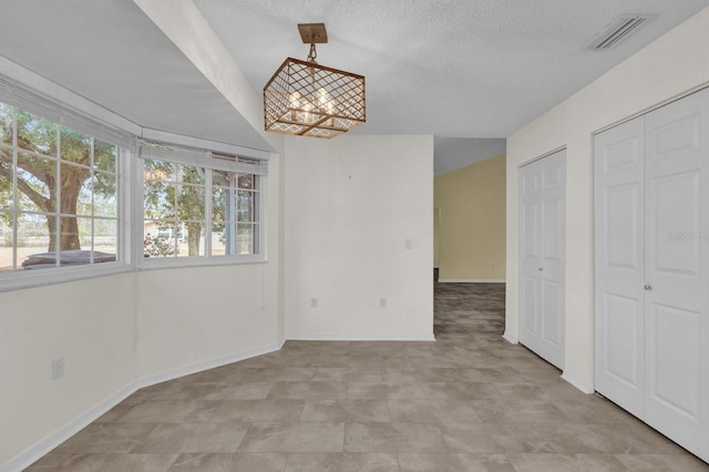 unfurnished dining area with a notable chandelier and a textured ceiling