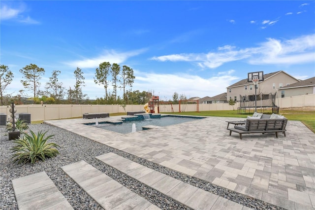 view of pool featuring outdoor lounge area, pool water feature, a yard, central AC, and a patio