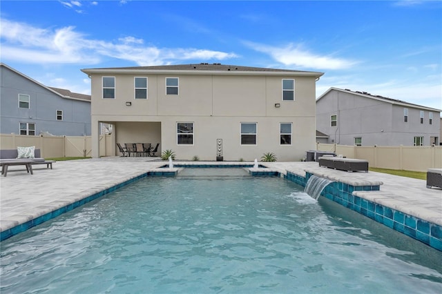 view of swimming pool featuring pool water feature, a patio, and a hot tub