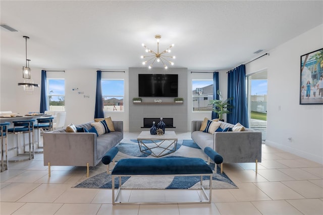 living room featuring light tile patterned flooring, a fireplace, and a chandelier